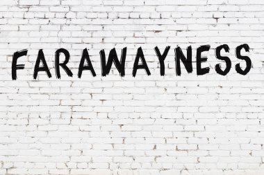 Üzerinde yazı olan beyaz tuğla duvar. Uzakta, siyah boyayla yazılmış.