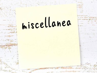 Tahta duvardaki sarı yapışkan notta el yazısı karışıklığı var.