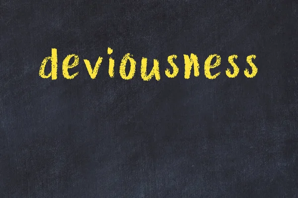 Tebeşir el yazısıyla yazılmış düzenbazlık siyah masada.