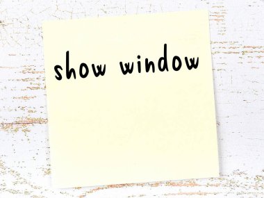 Vitrin hakkında hatırlatma kavramı. Tahta duvarda üzerinde yazı olan sarı yapışkan kağıt.