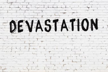 Yazılı beyaz tuğla duvar. Siyah boyayla yazılmış.