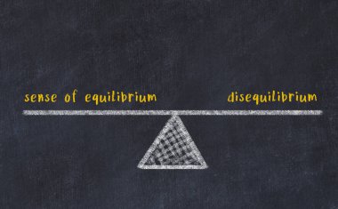 Denge duygusu ile dengesizlik arasındaki denge kavramı. Üzerinde pullar ve kelimeler olan siyah bir karatahta.