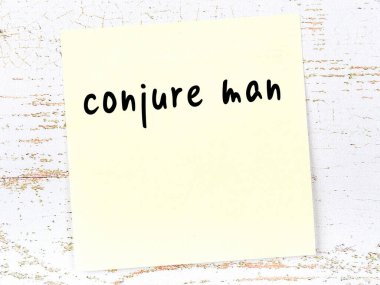 Tahta duvardaki sarı yapışkan notta el yazısıyla yazılmış hokkabaz.