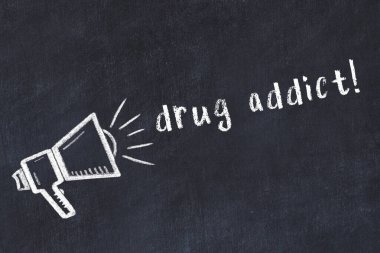 Hoparlörün tebeşir çizimi ve siyah masaya el yazısıyla yazılmış uyuşturucu bağımlısı.