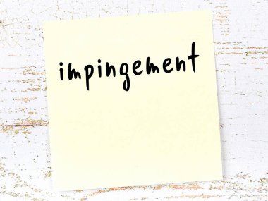 Tahta duvarda el yazısıyla yazılmış sarı yapışkan bir not var.