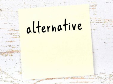 Alternatifi hatırlatma kavramı. Tahta duvarda üzerinde yazı olan sarı yapışkan kağıt.