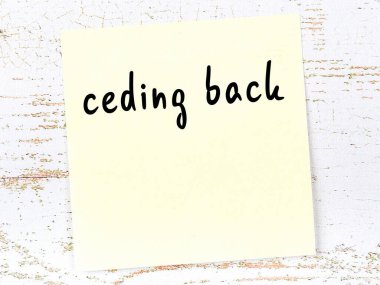 Ahşap duvarda sarı yapışkan bir not ve el yazısıyla yazılmış bir yazı var.