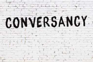 Üzerinde siyah boya bulunan beyaz tuğla bir duvar.