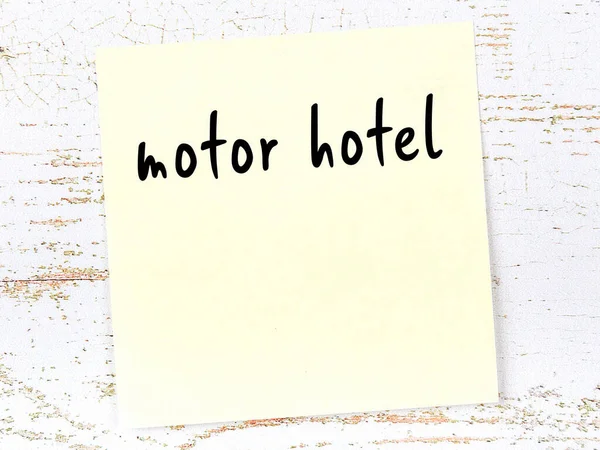 手書きの碑文モーターホテルと木製の壁に黄色の付箋 — ストック写真