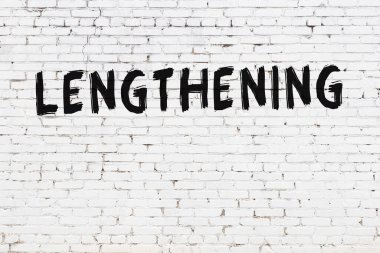 Yazılı beyaz tuğla duvar. Siyah boyalı, el yazısı uzatılıyor.