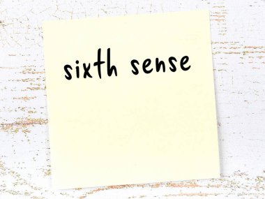 Altıncı his hakkında hatırlatma kavramı. Tahta duvarda üzerinde yazı olan sarı yapışkan kağıt.