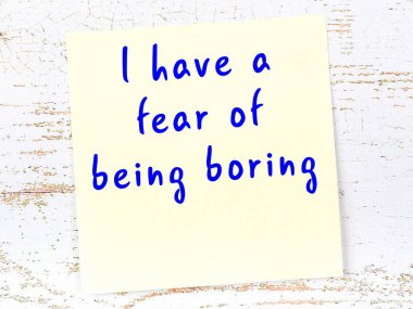 Tahta duvarda el yazısı motivasyon alıntısı olan sarı yapışkan not