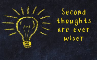 Bilgece bir alıntı ve siyah karatahtaya bir ampul çizimi