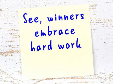 Sarı yapışkan not, ahşap duvarda el yazısıyla yazılmış zekice bir alıntıyla.