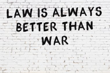 Beyaz tuğla duvara zekice alıntılar yazılı siyah bir yazı.