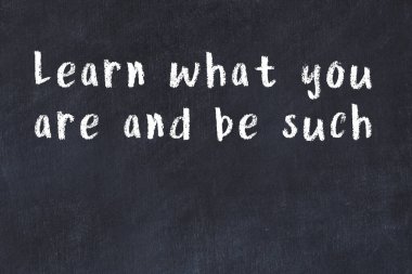 Siyah masa üzerine tebeşirle yazılmış zekice bir söz.