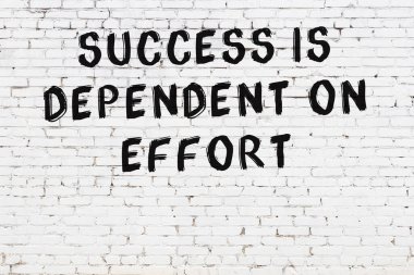 Üzerinde mantıklı alıntıların yazılı olduğu siyah boyanmış beyaz tuğla duvar.