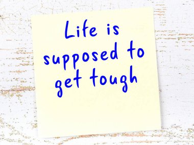 Tahta duvarda asılı sarı yapışkan nota elle yazılmış bilgece bir alıntı.