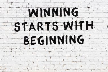 Beyaz tuğla duvar ve bilgece alıntıların yazılı olduğu siyah yazı.