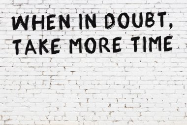 Beyaz tuğla duvar ve bilgece alıntıların yazılı olduğu siyah yazı.