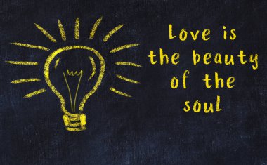 Bilgece bir alıntı ve siyah karatahtaya bir ampul çizimi