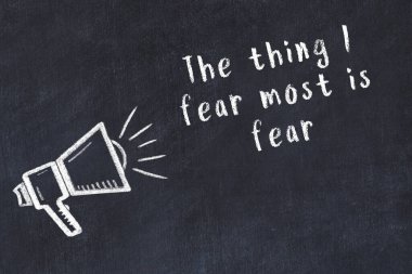 Bir hoparlörün tebeşir çizimi ve siyah karatahtaya el yazısıyla yazılmış alıntılar