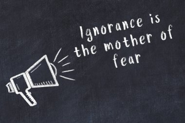 Bir hoparlörün tebeşir çizimi ve siyah karatahtaya el yazısıyla yazılmış alıntılar