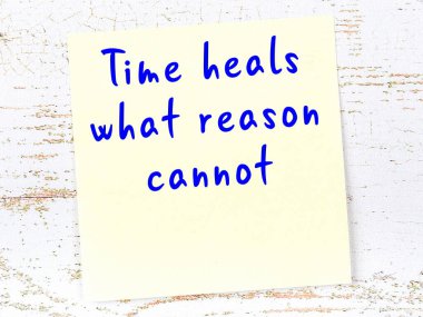 Tahta duvarda asılı sarı yapışkan nota elle yazılmış bilgece bir alıntı.