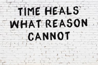 Üzerinde mantıklı alıntıların yazılı olduğu siyah boyanmış beyaz tuğla duvar.