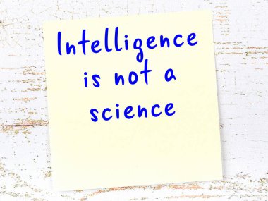 Sarı yapışkan not, ahşap duvarda el yazısıyla yazılmış zekice bir alıntıyla.