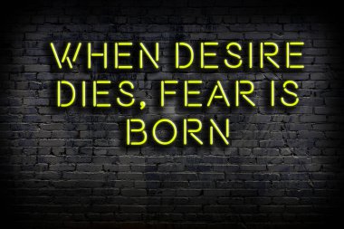 Tuğla duvardaki bilgece alıntıların neon yazıları üzerine gece görüşü