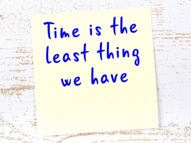 Sarı yapışkan not, ahşap duvarda el yazısıyla yazılmış zekice bir alıntıyla.