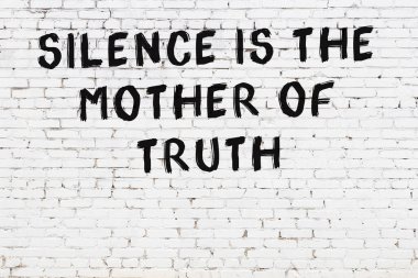 Beyaz tuğla duvar ve bilgece alıntıların yazılı olduğu siyah yazı.