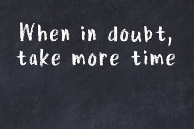 Siyah masa üzerine tebeşirle yazılmış zekice bir söz.