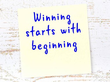 Tahta duvarda el yazısı motivasyon alıntısı olan sarı yapışkan not