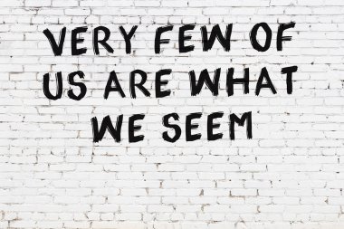 Üzerinde mantıklı alıntıların yazılı olduğu siyah boyanmış beyaz tuğla duvar.