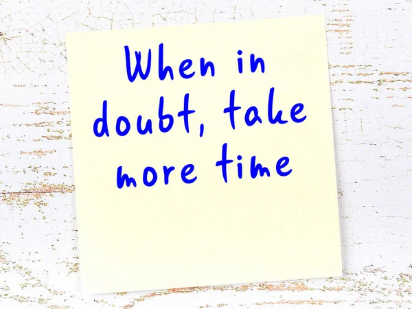 Tahta duvarda el yazısı motivasyon alıntısı olan sarı yapışkan not