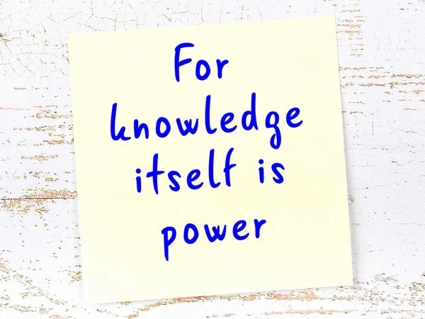 Sarı yapışkan not, ahşap duvarda el yazısıyla yazılmış zekice bir alıntıyla.