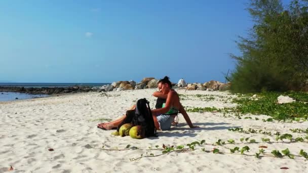 Δύο Νεαρές Φίλες Που Κάθονται Στην Αμμώδη Ακτή Τσάντες Δίπλα — Αρχείο Βίντεο
