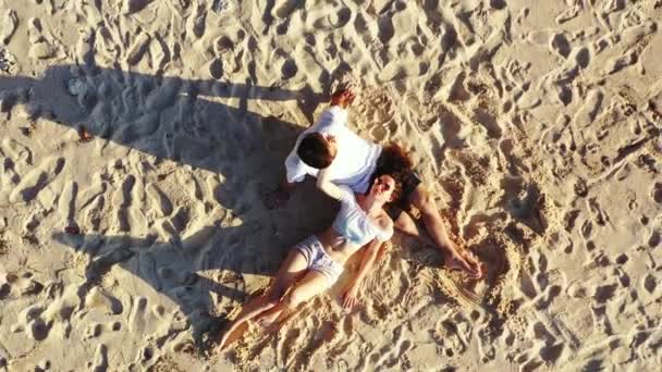 透き通った海の近くの砂浜でリラックスしている若いカップル 美しい海岸線と美しいカップル休息 — ストック動画