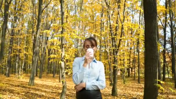 Pige drikker kaffe i parken – Stock-video