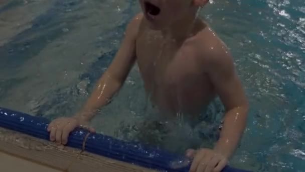 Aranyos fiú fürdőruha szemüveg gyakorolni úszás medence — Stock videók