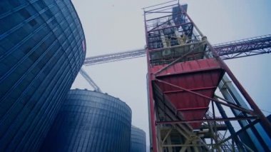 Gökyüzü arka planında ticari tahıl siloları. Tarımsal hasat için çelik deposu
