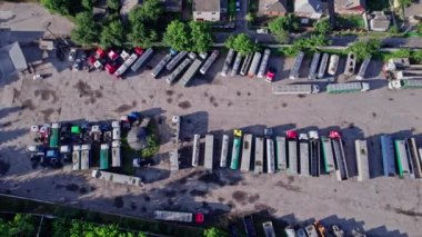 Lojistik parkında kargo konteynırları yükleyen yarı kamyonlar.