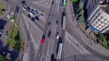 İnsansız hava aracı banliyödeki yolların kesişiminden yükseliyor. Arabalar farklı yönlere gider.