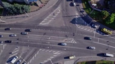 İnsansız hava aracı banliyödeki yolların kesişiminden yükseliyor. Arabalar farklı yönlere gider.