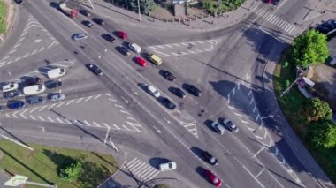 Şehirdeki bir kavşakta giden trafik arabalarının hava görüntüsü.