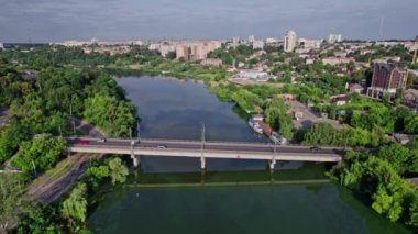 Nehir kenarındaki küçük şehrin panoramik görüntüsü, köprü, hava aracı görüntüsü