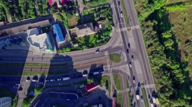 Şehirdeki bir kavşakta giden trafik arabalarının hava görüntüsü.