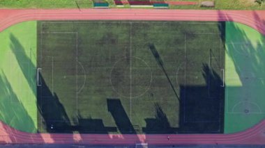 Önünde küçük bir futbol stadyumu olan havacılık şehri manzarası.